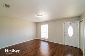 San Antonio house for rent - the living room of a house with wood flooring and a white door
