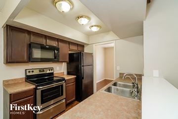 San Antonio house for rent - a kitchen with stainless steel appliances and wooden cabinets