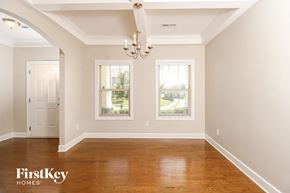 Whitsett house for rent - a empty dining room with a wood floor and two windows
