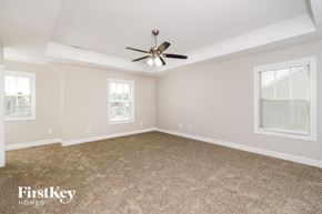 Whitsett house for rent - a bedroom with carpet and a ceiling fan