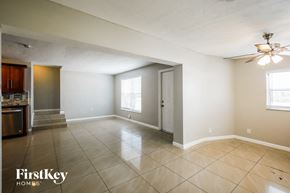 Hollywood house for rent - an empty living room with a ceiling fan and tile flooring