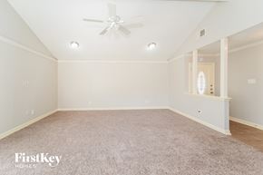 Houston house for rent - A spacious room with a carpeted floor and a ceiling fan.