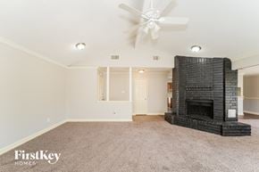 Houston house for rent - A living room with a fireplace and a ceiling fan.