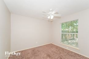 Houston house for rent - A room with a ceiling fan and a window showing trees outside.