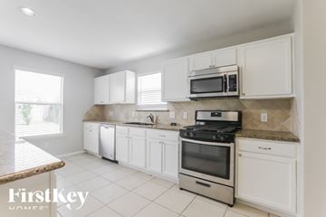 Spring house for rent - A kitchen with white cabinets and appliances.