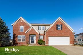 Morrow house for rent - a red brick house with a white garage door and a green lawn
