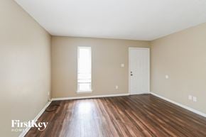 Memphis house for rent - the spacious living room with hardwood floors and a white door