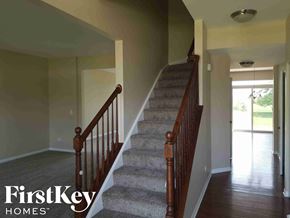 Mchenry house for rent - A staircase with a carpeted runner and wooden balusters.