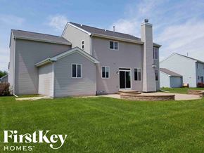 Mchenry house for rent - A house with a grey exterior and a stone pathway leading to the front door.