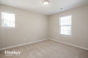 Charlotte house for rent - a bedroom with a carpeted floor and two windows