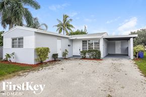 Hollywood house for rent - a white house with a driveway and palm trees