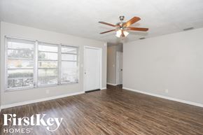 Hollywood house for rent - an empty living room with a ceiling fan and a window