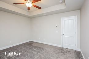 Gainesville house for rent - a bedroom with a carpeted floor and a ceiling fan