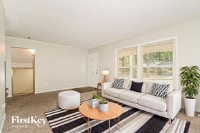 Florissant house for rent - A living room with a white couch, a coffee table, and a rug.