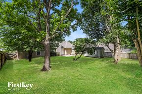 Memphis house for rent - a yard with trees and a house in the background