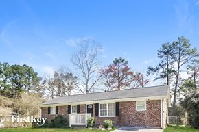 Lithia Springs house for rent - A brick house with a porch and a sign that says "Firstkey Homes".