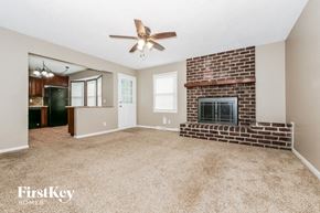 Grandview house for rent - A spacious living room with a brick fireplace and a ceiling fan.
