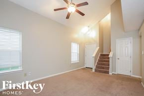 Indianapolis house for rent - an empty living room with a ceiling fan and a staircase