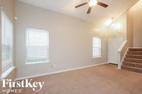 Indianapolis house for rent - an empty living room with stairs and a ceiling fan