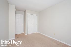 Indianapolis house for rent - a bedroom with two closets and a carpeted floor