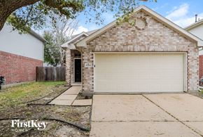 Katy house for rent - a white brick house with a white garage door