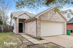 Katy house for rent - a tan brick house with a white garage door