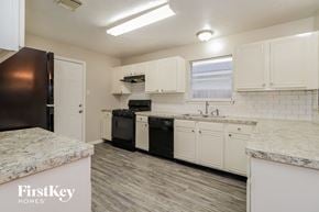 Katy house for rent - a white kitchen with black appliances and white cabinets