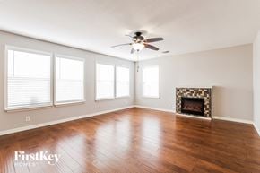 Converse house for rent - an empty living room with a ceiling fan and a fireplace
