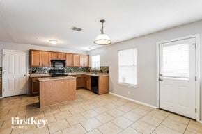 Converse house for rent - a large kitchen with wood cabinets and tile flooring