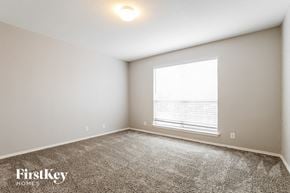 Converse house for rent - a bedroom with a large window and a carpeted floor