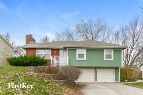 Parkville house for rent - a green house with a white garage door
