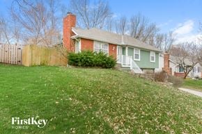Parkville house for rent - a green house with a yard and a fence