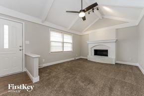 Parkville house for rent - a living room with a fireplace and a ceiling fan