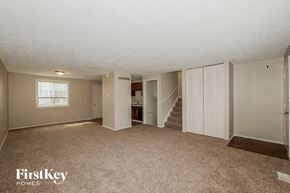 Indianapolis house for rent - A spacious room with a staircase leading to another level.