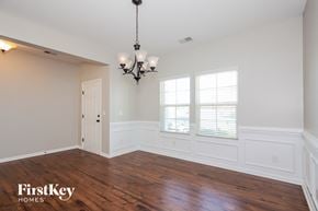 Charlotte house for rent - an empty dining room with wood floors and a chandelier