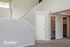 Indianapolis house for rent - a bedroom with a door to a closet and a staircase
