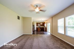 Morrow house for rent - an empty living room with a ceiling fan and a kitchen