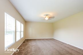 Morrow house for rent - an empty living room with a ceiling fan and large windows