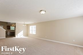 Indianapolis house for rent - A spacious room with a carpeted floor and a light fixture on the ceiling.