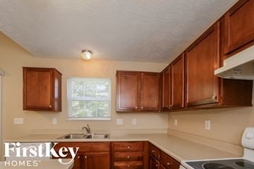Indianapolis house for rent - A kitchen with wooden cabinets and a stove top oven.
