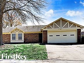 Memphis house for rent - A house with a garage and a tree in front of it.
