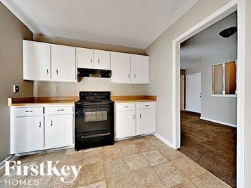 Memphis house for rent - A kitchen with white cabinets and a black stove top oven.