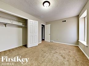 Memphis house for rent - A bedroom with a carpeted floor and a closet with a white door.