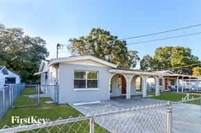 Tampa house for rent - a small house with a fenced in yard and a chain link fence