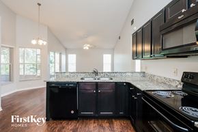 Orlando house for rent - A kitchen with black cabinets and a granite countertop.