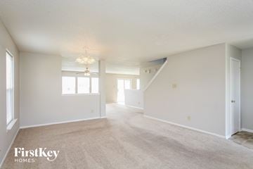 Mccordsville house for rent - the living room and dining room of an apartment with carpet and white walls