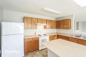 Mccordsville house for rent - a kitchen with white appliances and wooden cabinets