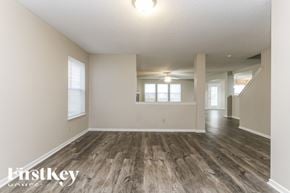 Mccordsville house for rent - A spacious room with wooden flooring and white walls.