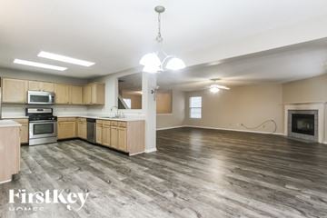 Mccordsville house for rent - A spacious kitchen with wooden cabinets and a grey floor.