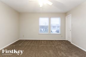 Mccordsville house for rent - A room with a carpeted floor and a window with a view of a building outside.